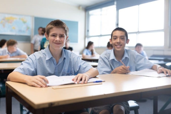 Two junior boys sitting at a desk